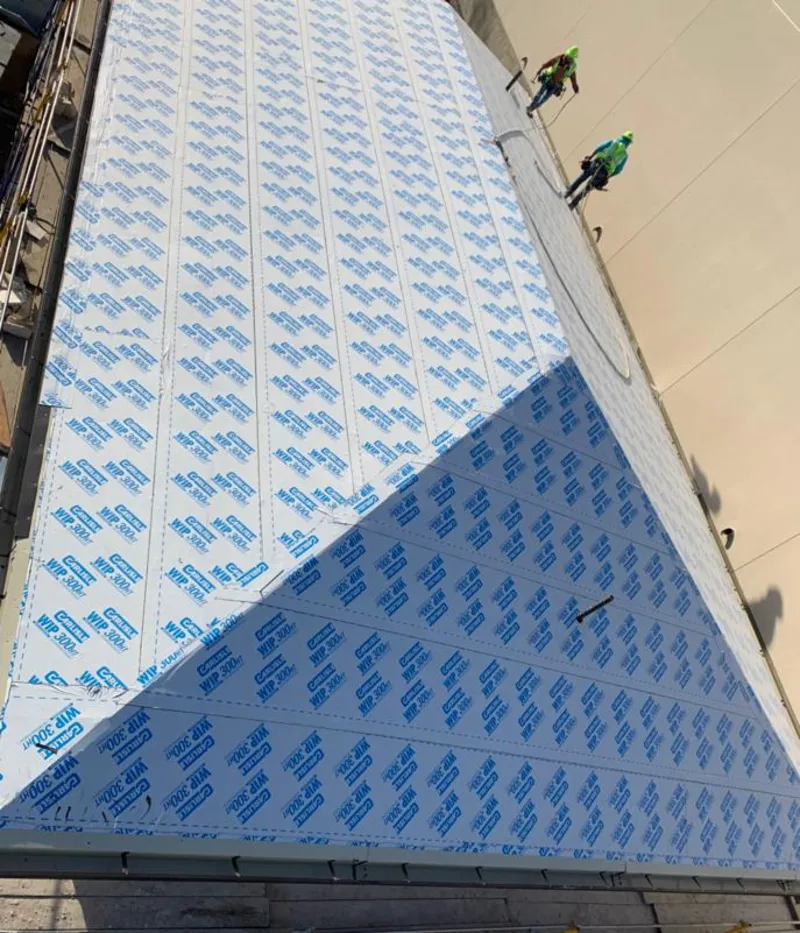 Professional roofers installing underlayment on a metal roof in Grand Terrace